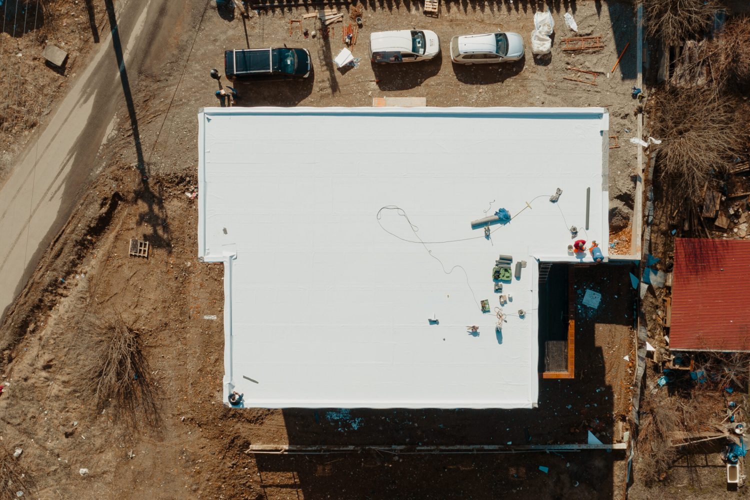 Aerial view of an apartment building with flat roof in construction, ballasted system with geotextile, PVC or EPDM membrane